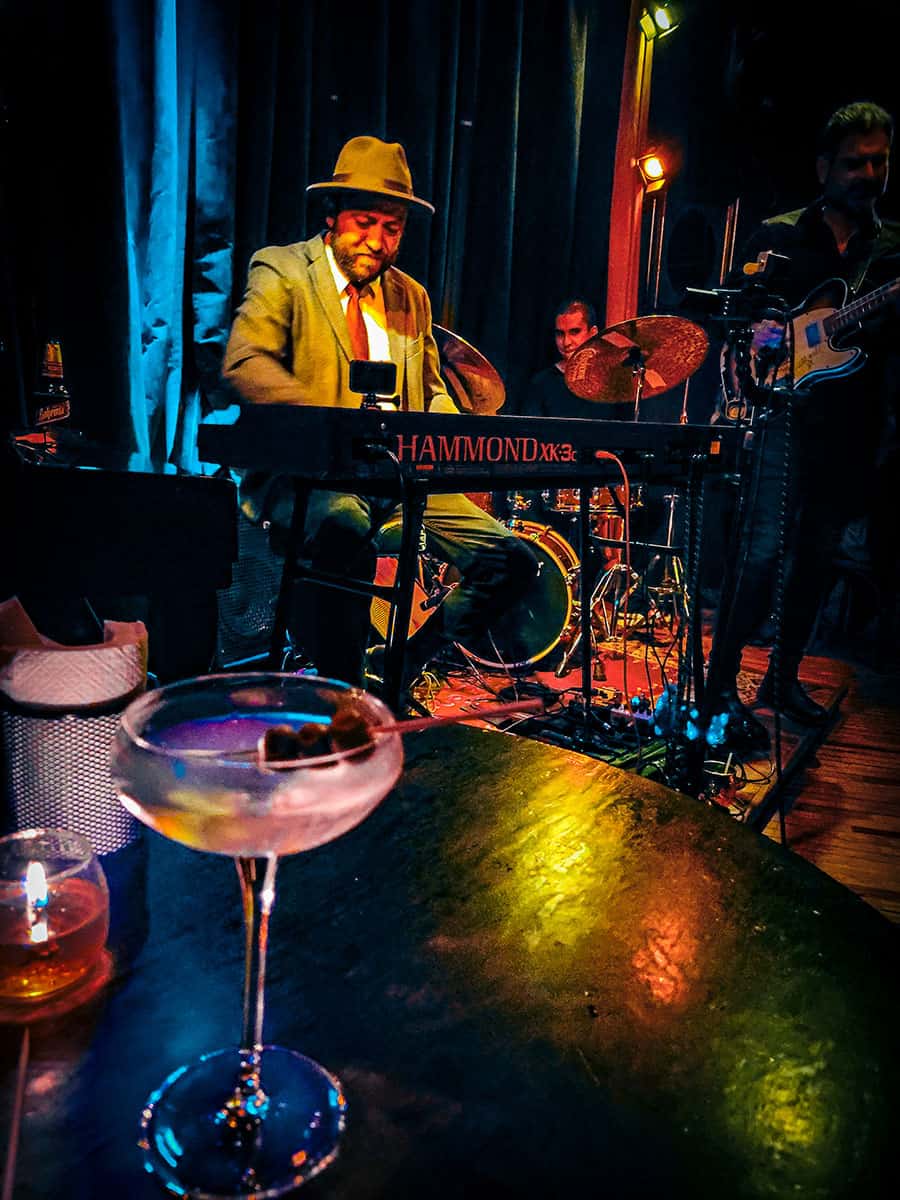 A martini sits on a candlelit table with a jazz trio playing at Casa Franca, Mexico City in the background.